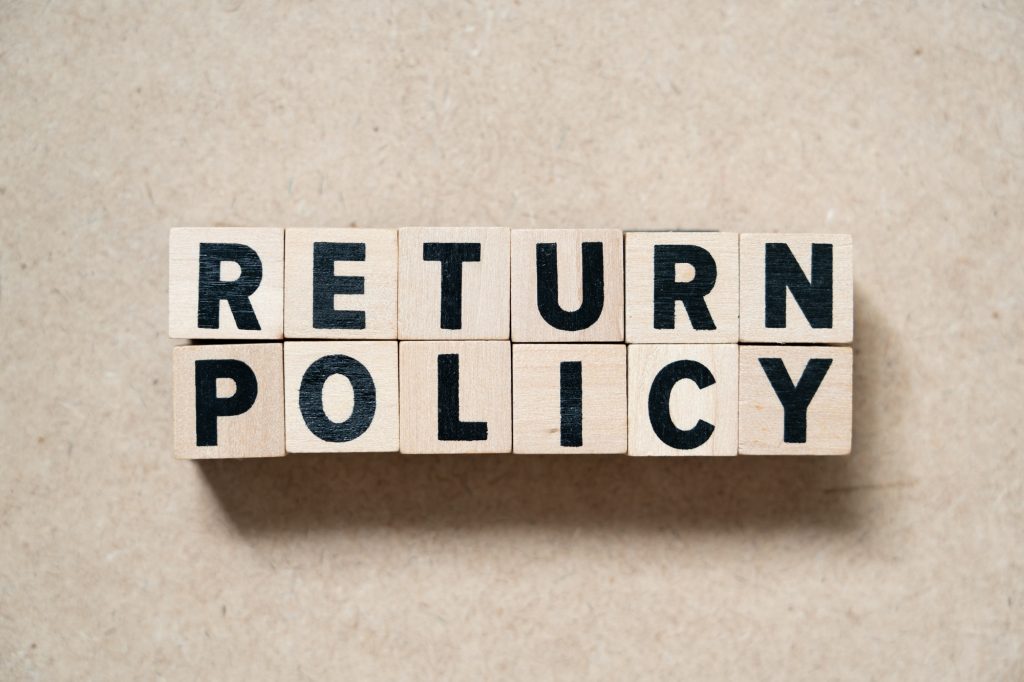 Alphabet letter block in word return policy on wood background