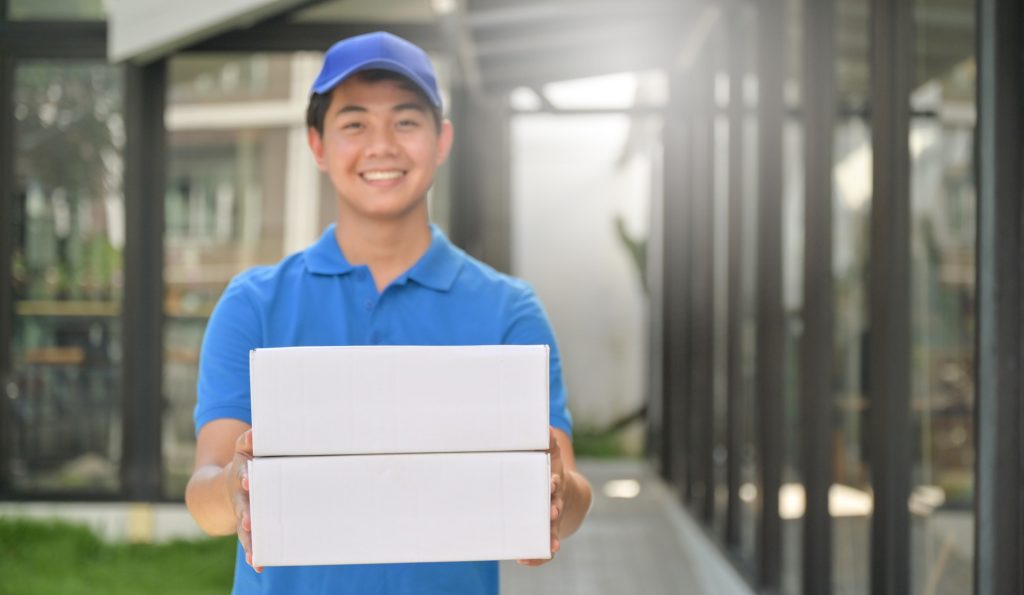 Parcel delivery worker holding a box in hand ready to deliver to customer, Delivery concept.