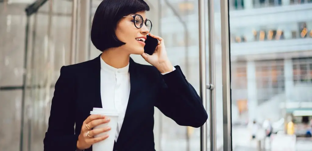 Successful businesswoman talking on smartphone on street