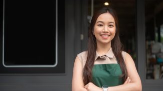 Young Asian woman cafe owner entrepreneur smiling in coffee shop, small business concept
